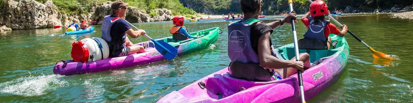 Mensen kajakken op een rivier tussen groene bergen