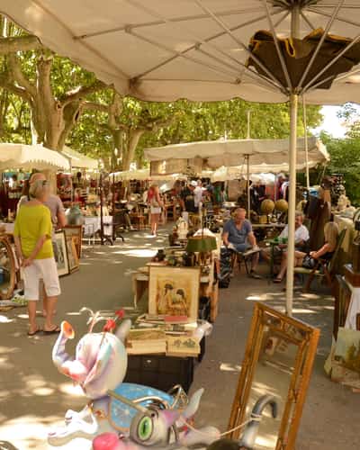 Buitenmarkt met antiek en schilderijen onder parasols